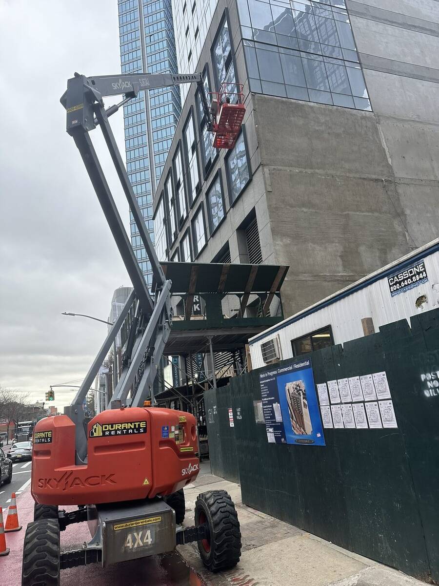 Boom lift reaching an upper-floor facade for inspection