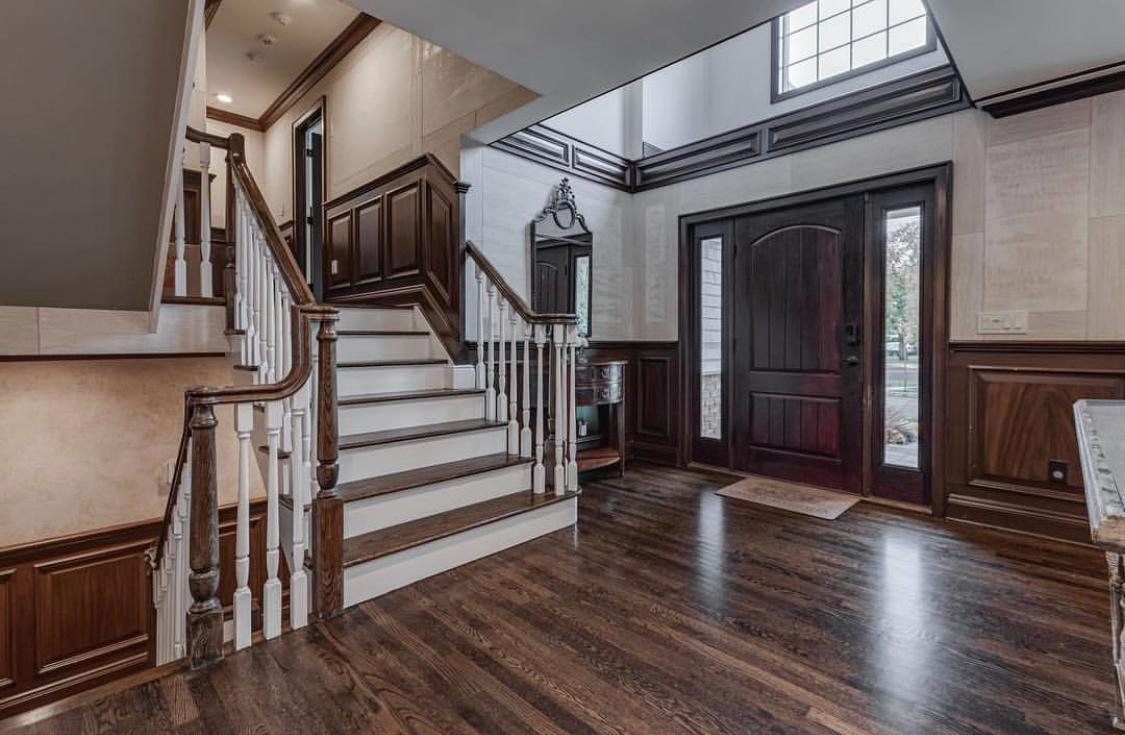 Wood-paneled entry foyer with custom staircase
