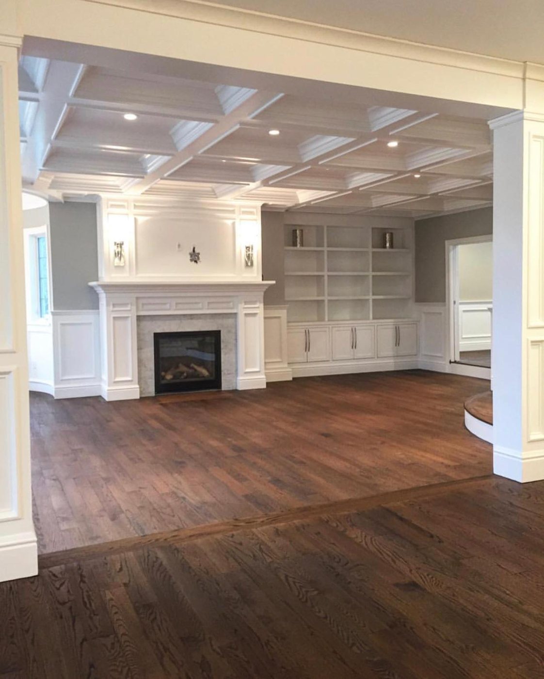 Great room with custom fireplace mantel and built-in bookshelves