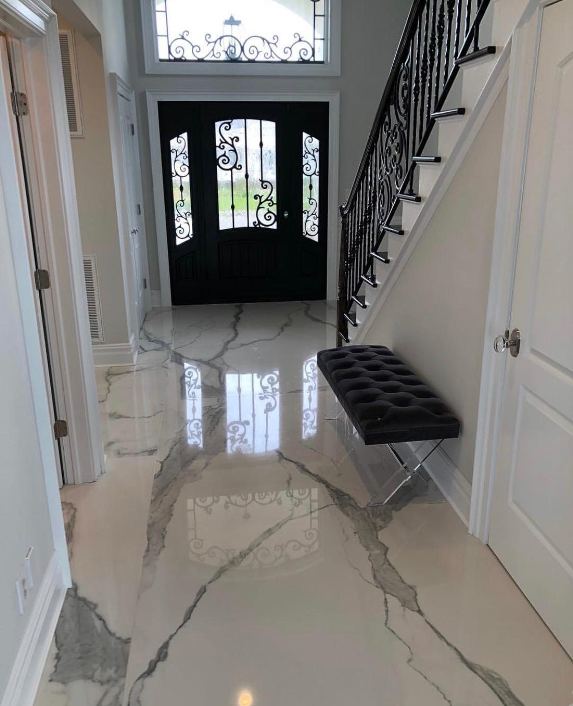 Marble entry hallway with wrought-iron staircase railing