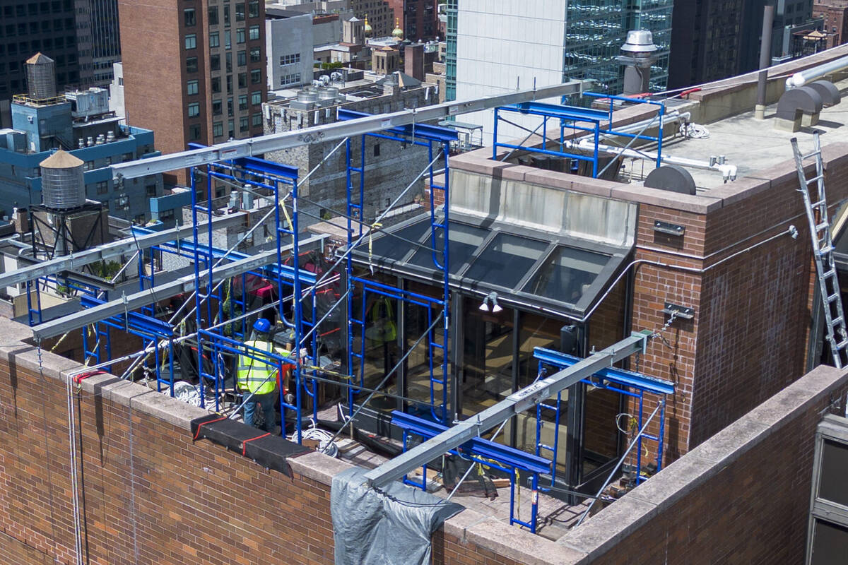 Sidewalk shed and scaffolding installation along a building facade